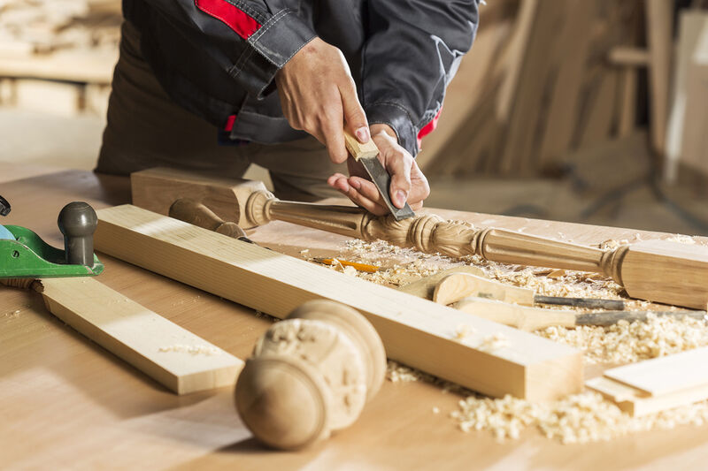 An image showing the craftsmanship of a carpenter at work, creating intricate woodwork with precision.