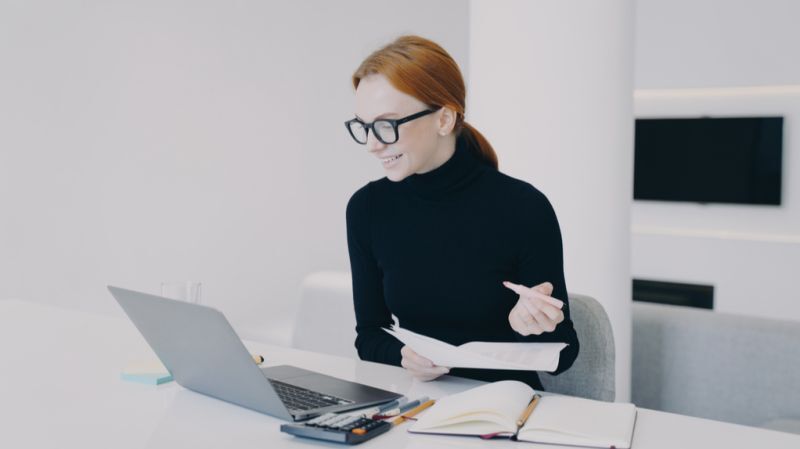 Wealth manager working at a modern office desk with a laptop, documents, and essential office supplies.