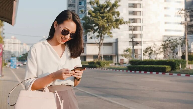 A woman using a smartphone, symbolizing the ease of access and efficiency in independent wealth management, similar to Uber's approach.