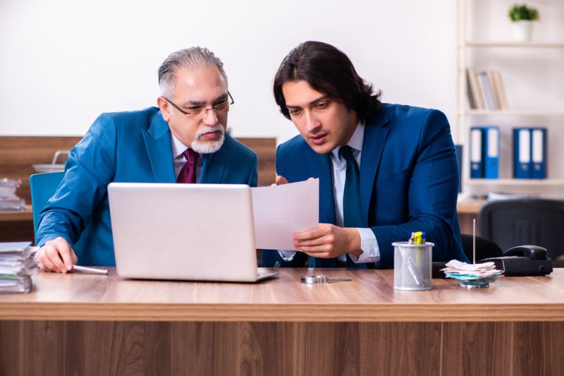 Two wealth managers discussing long-term financial plans in a modern office setting.