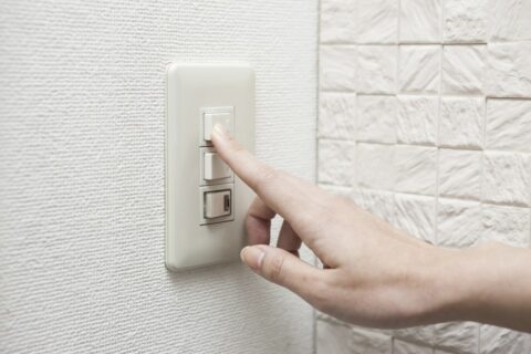 A finger switching a light, symbolising the transition to independent wealth management for better compensation.