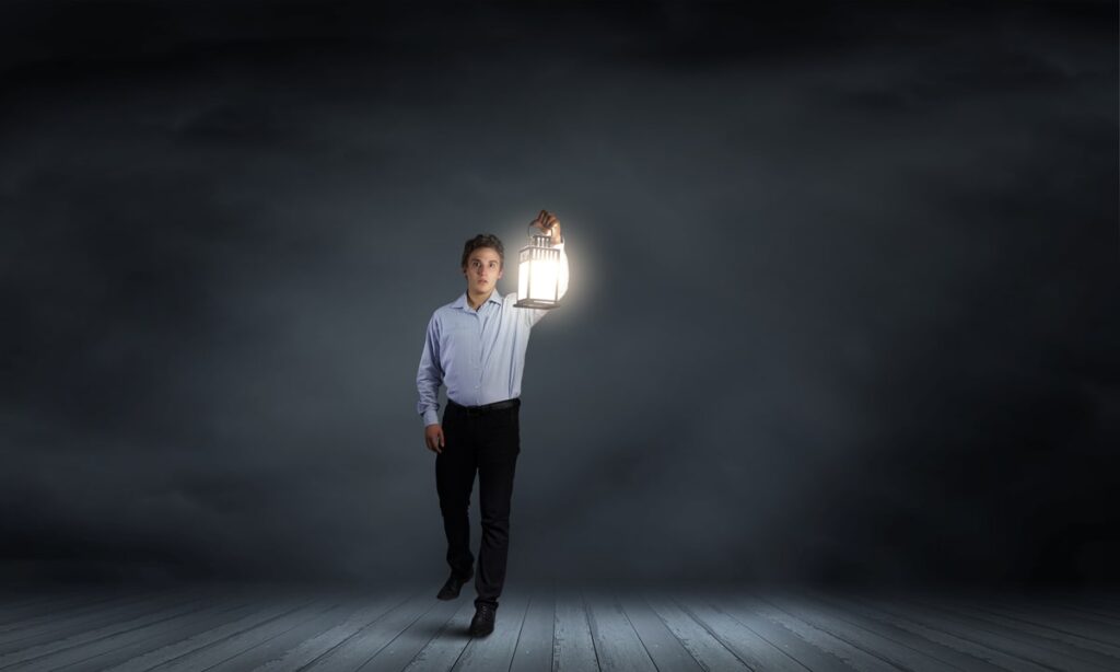 Ein professioneller Mann in einem Hemd, der eine leuchtende Laterne in der Hand hält, symbolisiert Führung und Orientierung in einer Karriere als Vermögensverwalter.
