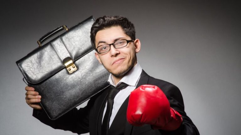 Confident professional in a tailored suit, holding a briefcase and wearing a red boxing glove