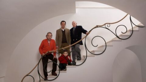 Vier Generationen einer Familie stehen auf einer Treppe und symbolisieren die Nachfolgeplanung und die Zukunft der Vermögensverwaltung.