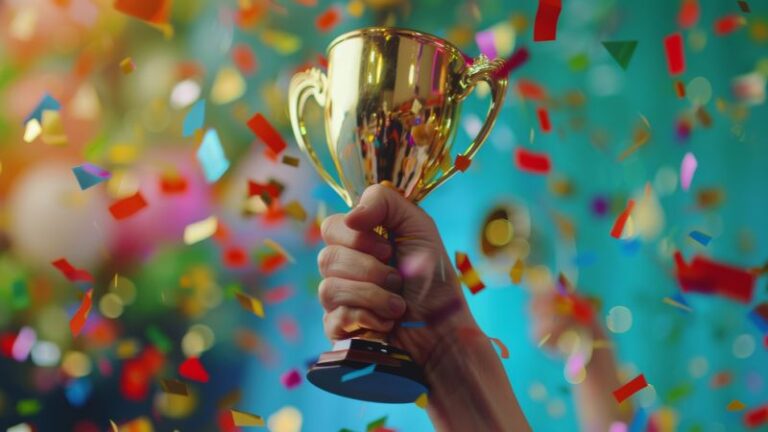 A hand holding a golden trophy, surrounded by colourful confetti, symbolising achievement and excellence at the Private Banking Wealth Awards 2025.