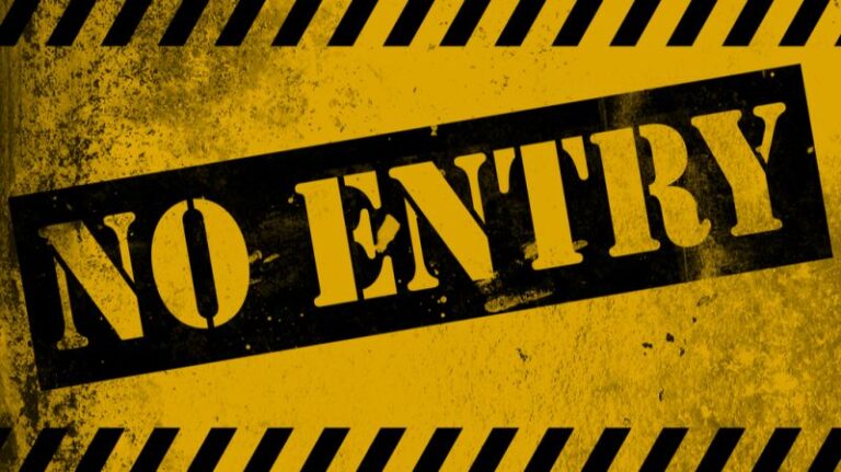 Ein gelbes Warnschild mit der Aufschrift „NO ENTRY“, das symbolisiert, wie regulatorische Hindernisse kleinere Investoren vom Zugang zu besseren Investitionsmöglichkeiten abhalten.