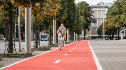 Eine Frau fährt auf einem roten Radweg, der den Datenfluss im AIA und im Private Banking Trust symbolisiert.