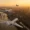 Drei Privatjets, die bei Sonnenuntergang über die Londoner Skyline fliegen, wobei die Tower Bridge, The Shard und Big Ben zu sehen sind, symbolisieren den Wegzug von UHNWIs aus dem Vereinigten Königreich nach der Steuerreform für Nichtvermögende.