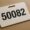 Private banker ID badge with number 50082 on a desk, symbolising lack of individuality in large institutions