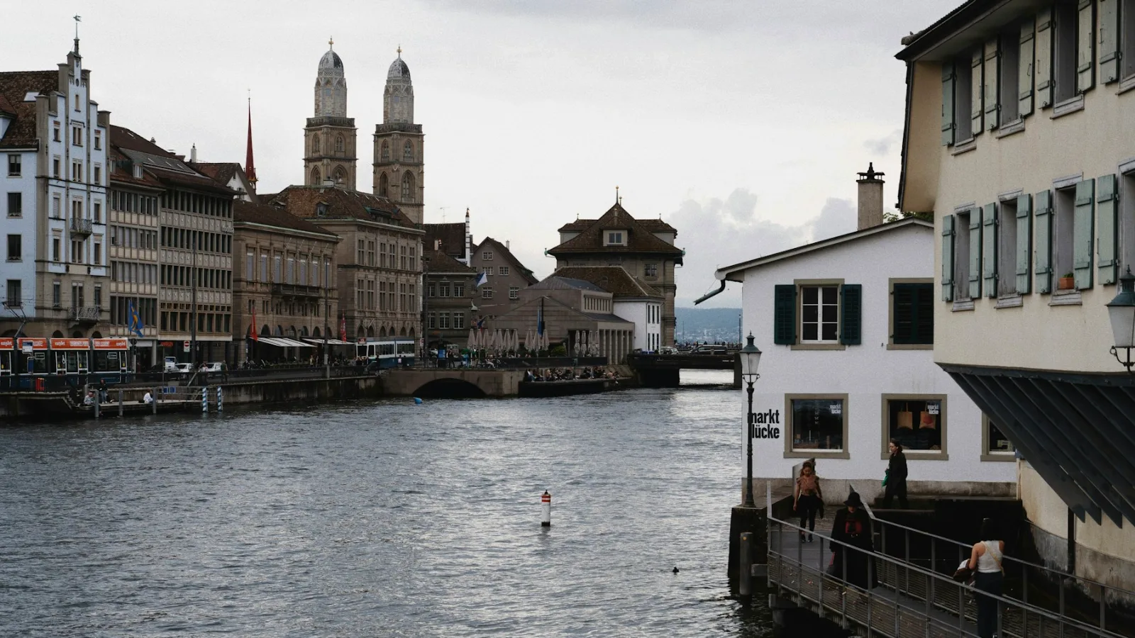 Ansicht über den Limmat hin zum Grossmünster in Zürich, wo ein wohlhabender Kunde nach einem unabhängigen Vermögensverwalter sucht.